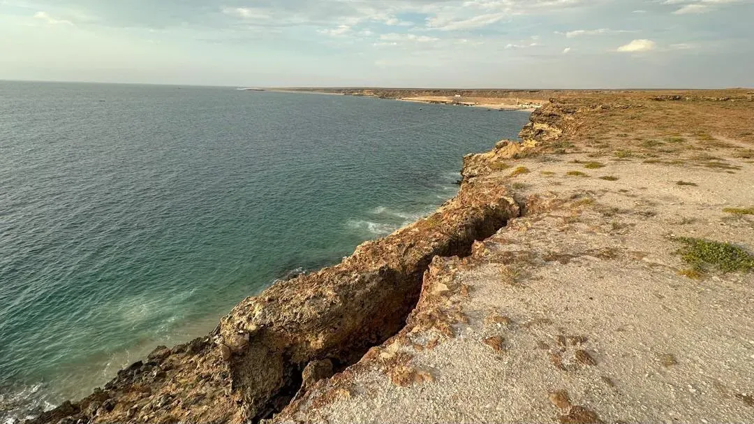 The wild coast of Baía das Pipas curving to the horizon