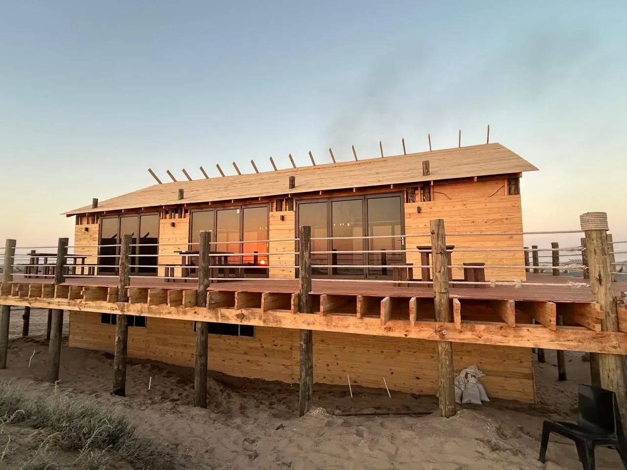 A stilted timber chalet at Meob Lodge in the last light