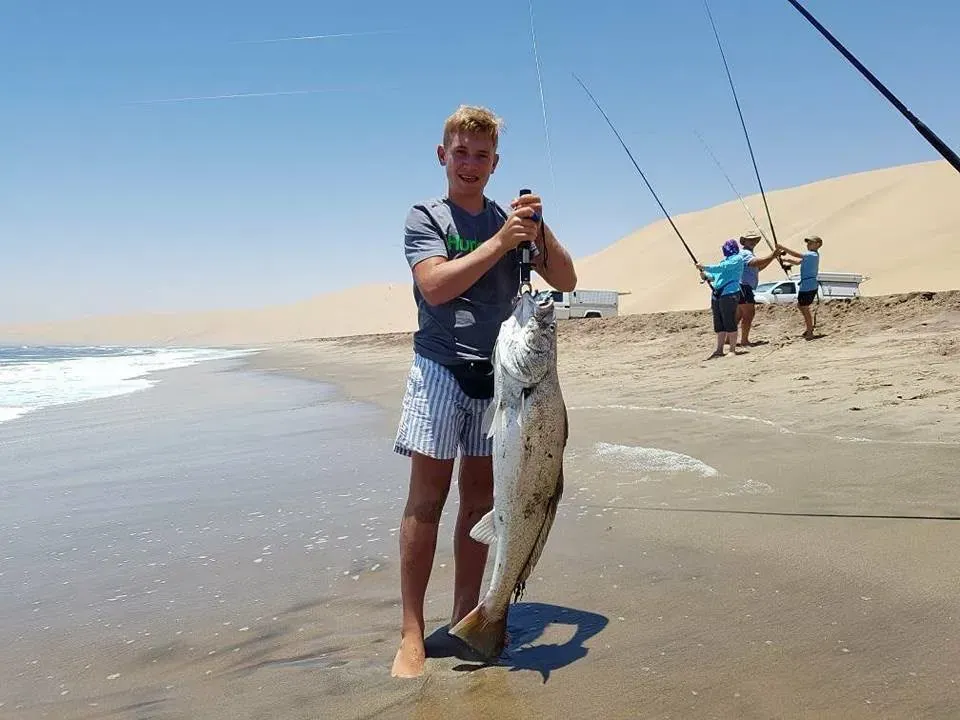 Surfcasting the Atlantic breakers beneath the towering dunes
