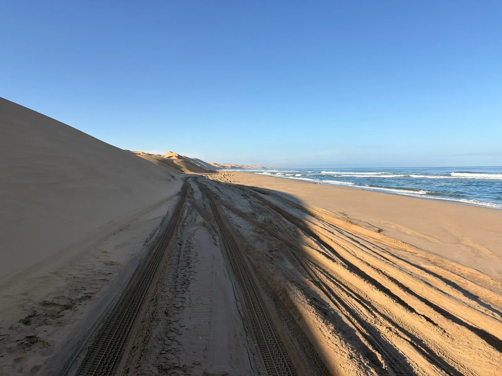 Driving the tide line between towering dune and Atlantic surf