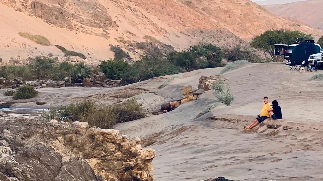Resting on the smooth rock slabs beside the Kunene rapids